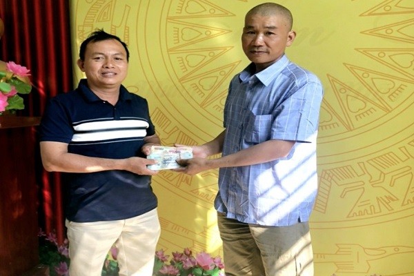 Anh Nguyễn Bá Miên (đứng bên trái) trao trả lại số tiền 45 triệu đồng nhặt được, cho anh Ngô Thành Lê.