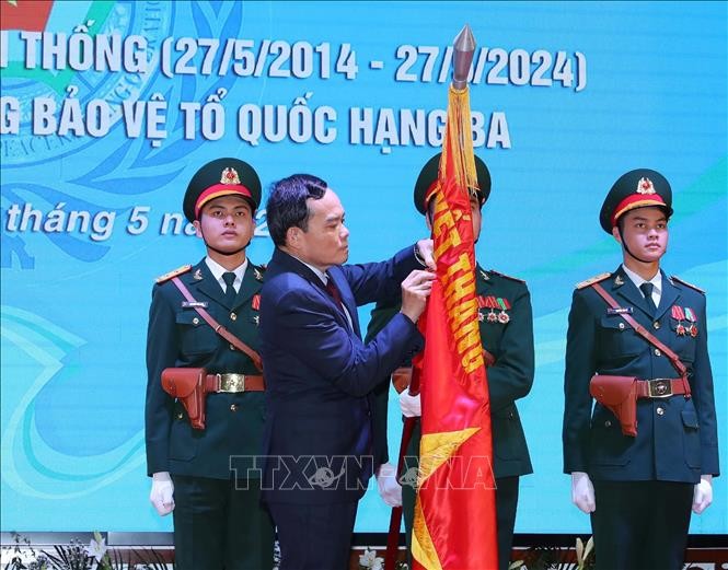 Phó Thủ tướng Trần Lưu Quang gắn Huân chương Bảo vệ Tổ quốc hạng Ba lên cờ truyền thống của Cục GGHB Việt Nam. Ảnh: Trọng Đức/TTXVN