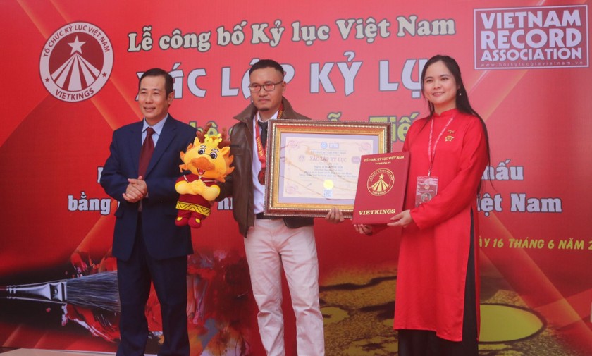 Nghệ sĩ Nguyễn Tiến xác nhận kỷ lục “Nghệ sĩ vẽ tranh trình diễn trên sân khấu bằng nhiều loại hình và chất liệu nhất Việt Nam”. Ảnh: NVCC