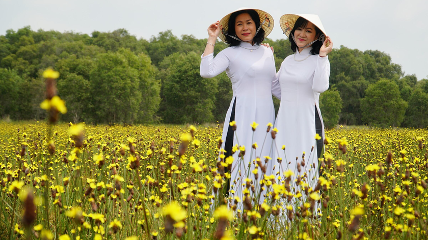 Hai du khách trong trang phục truyền thống chụp ảnh với hoa hoàng đầu ấn. Ảnh: Ngọc Tài