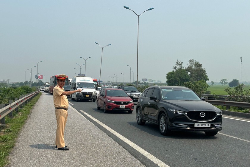 Thượng tá Nguyễn Mạnh Thắng - Đội trưởng Đội Tuần tra kiểm soát giao thông đường bộ số 3, Cục Cảnh sát giao thông thực hiện phân luồng, hỗ trợ các phương tiện di chuyển trên tuyến cao tốc.
