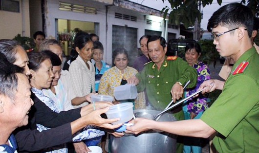 Đại tá Trần Quyết Liệt múc “cháo công an” cho bệnh nhân nghèo ở Mỹ Tú - Ảnh: Chí Quốc