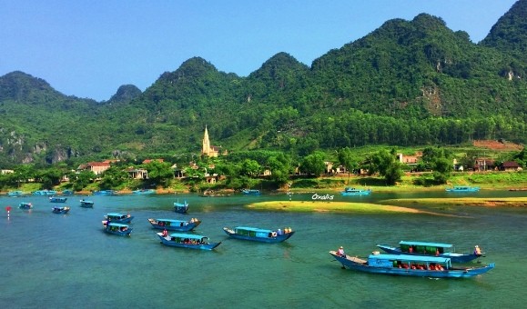 Thuyền chở du khách tấp nập vào động Phong Nha qua sông Son.