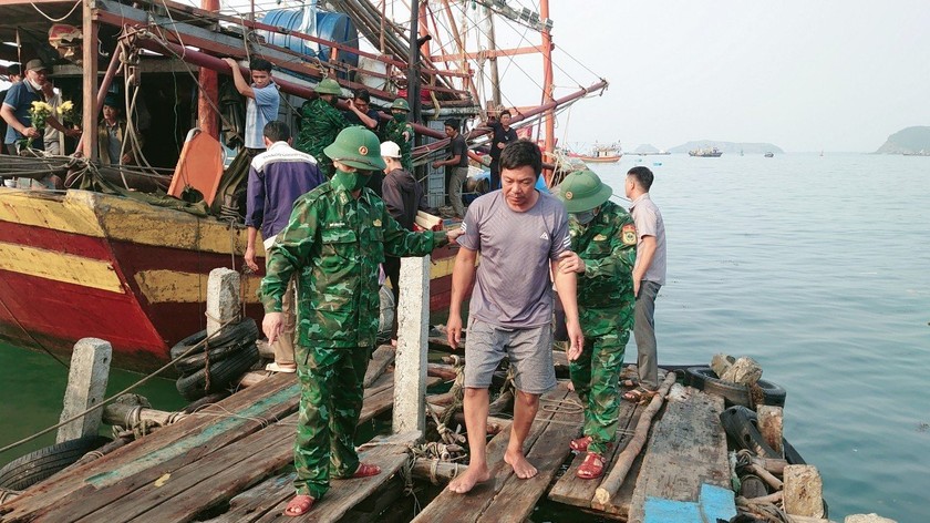 Lực lượng cứu hộ Bộ đội Biên phòng tỉnh Quảng Bình đưa những thuyền viên từ tàu cá lên bờ để.(Ảnh: BĐBP Quảng Bình)