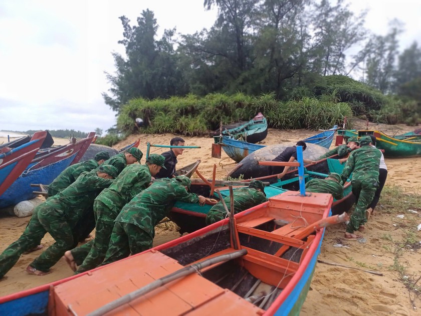 Lực lượng Đồn Biên phòng Lý Hòa giúp ngư dân đẩy thuyền vào sâu trong bờ tránh bão.