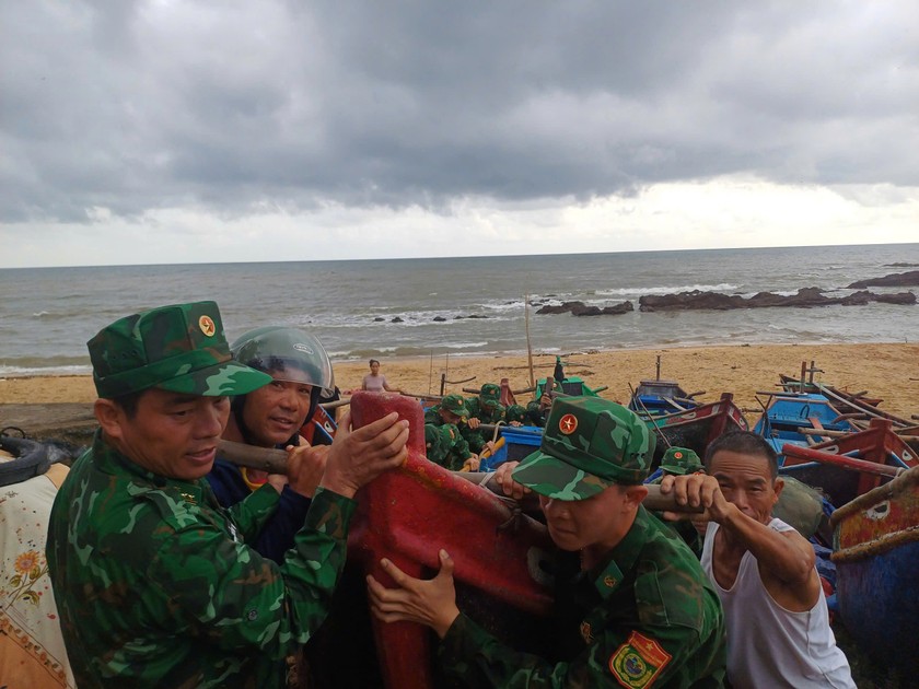 Lực lượng Đồn Biên phòng Lý Hòa giúp ngư dân đẩy thuyền vào sâu trong bờ tránh bão.