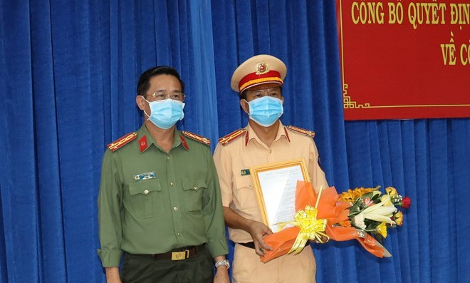 Đại tá Nguyễn Văn Trãi, Giám đốc Công an tỉnh Tây Ninh, trao quyết định bổ nhiệm của Bộ Trưởng Bộ Công an cho Thượng tá Phan Văn Triều (phải)