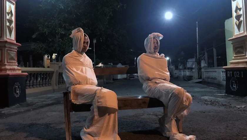 Các pocong ngồi canh không cho người dân ra khỏi nhà. Ảnh: Reuters