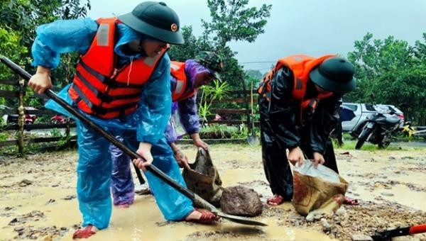 Cán bộ, chiến sĩ Đồn Biên phòng Cửa khẩu Hồng Vân giúp các gia đình khắc phục sạt lở tại thôn 5, xã Hồng Vân, huyện A Lưới, tỉnh Thừa Thiên-Huế.Ảnh: Lê Tiên/QĐND