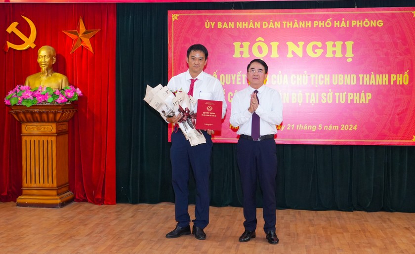 Phó Chủ tịch UBND TP Lê Khắc Nam trao Quyết định, tặng hoa chúc mừng ông Trần Đức Huấn.