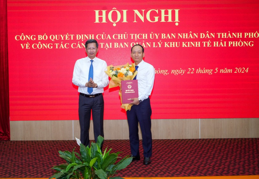 Phó chủ tịch Thường trực UBND thành phố Lê Anh Quân trao quyết định và tặng hoa chúc mừng ông Nguyễn Quang Minh.