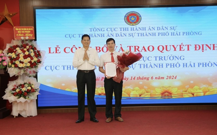 Ông Nguyễn Văn Lực, Phó Tổng cục trưởng Tổng cục THADS trao quyết định và tặng hoa cho ông Đỗ Văn Chọn.