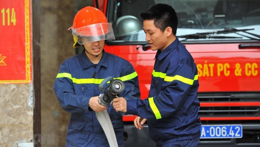 Trung úy Vũ Ngọc Hoàng (phải) hướng dẫn nghiệp vụ cho chiến sỹ mới tại đơn vị. (Ảnh: Minh Đức/TTXVN)