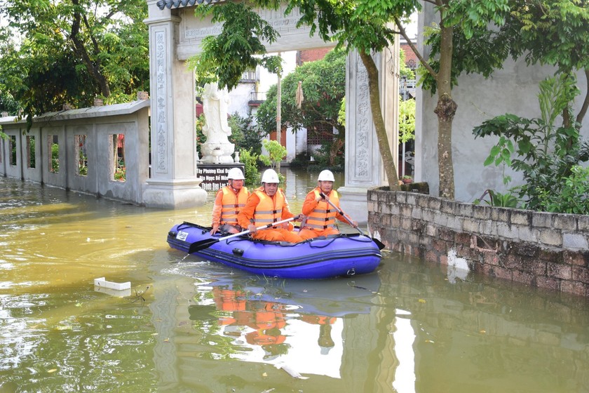 Cán bộ công nhân viên EVNHANOI sử dụng thuyền phao kiểm tra đóng, cắt điện tại vùng ngập úng.