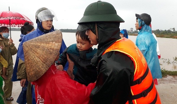 Cán bộ, chiến sĩ Ban CHQS huyện Phú Lộc, Bộ CHQS tỉnh Thừa Thiên Huế di dời người dân thôn Châu Thành đến nơi tránh trú an toàn.