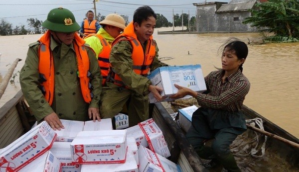 Đại tá Nguyễn Tiến Nam, Giám đốc Công an tỉnh trao nhu yếu phẩm cho bà con vùng lũ.