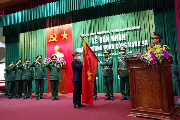 Thừa ủy quyền của Chủ tịch nước, Bí thư Tỉnh ủy Quảng Bình Vũ Đại Thắng gắn Huân chương Quân công hạng Ba lên lá cờ truyền thống của Bộ CHQS tỉnh.
