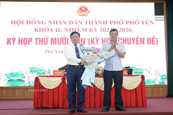 Phó Chủ tịch Thường trực UBND tỉnh Đặng Xuân Trường (bên phải) tặng hoa chúc mừng đồng chí tân Chủ tịch HĐND TP. Phổ Yên (bên trái) (Ảnh: Thainguyen.gov)