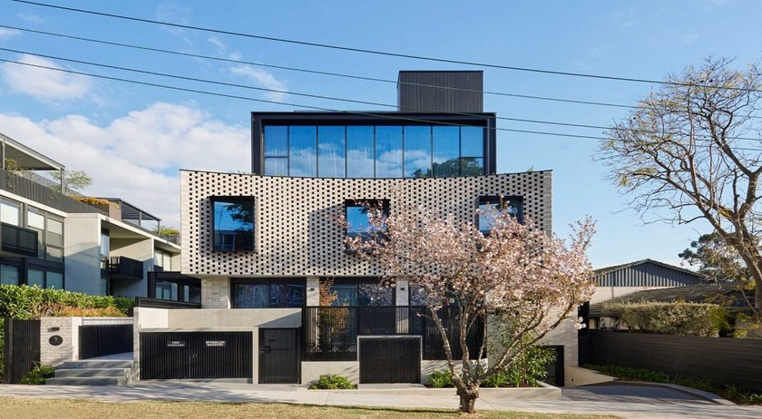 Các khung màu đen đổ bóng lên những viên gạch cong, càng làm tăng thêm sự thú vị cho ngoại thất của căn nhà.