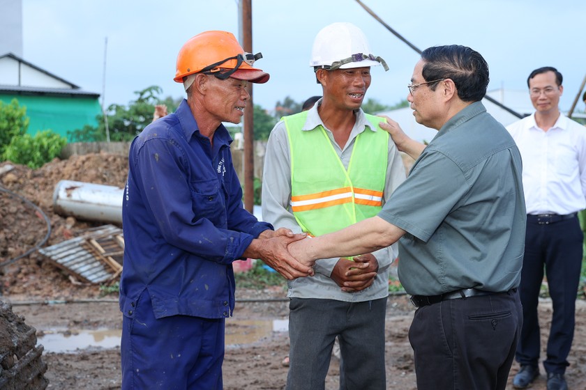 Thủ tướng Phạm Minh Chính động viên công nhân đang làm việc trên công trường Dự án. (Ảnh: VGP/Nhật Bắc).
