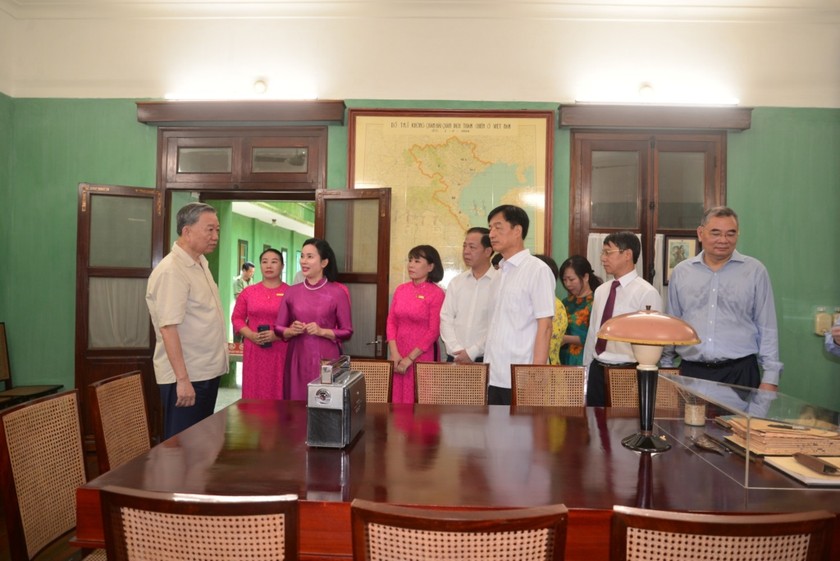 Tổng Bí thư, Chủ tịch nước Tô Lâm nghe đồng chí Lê Thị Phượng - Bí thư Đảng ủy, Giám đốc Khu Di tích báo cáo tình hình Khu Di tích đầu năm 2024 khi vào dâng hương tưởng niệm Chủ tịch Hồ Chí Minh tại Nhà 67, ngày 4/8/2024. (Ảnh: BQLKDT)