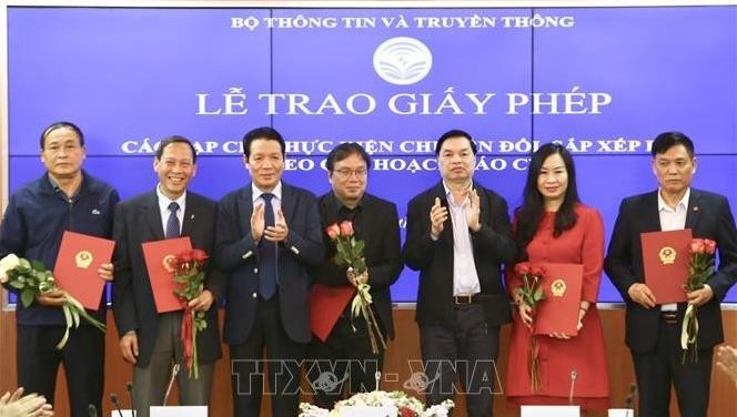 Phó trưởng Ban Tuyên giáo Trung ương Lê Mạnh Hùng và Thứ trưởng Bộ TT&TT Hoàng Vĩnh Bảo trao giấy phép cho 18 tạp chí thực hiện chuyển đổi, sắp xếp lại theo quy hoạch báo chí. Ảnh: TTXVN