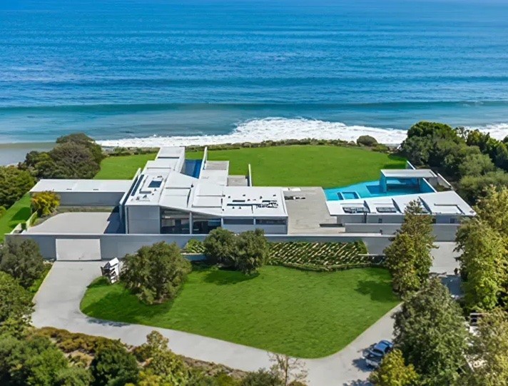 The spacious backyard features a swimming pool and ends with a cliff overlooking the beach.
