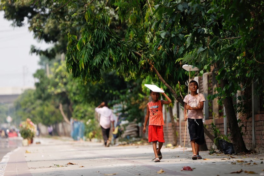 Trẻ em cầm tấm xốp để che nắng ở Dhaka, Bangladesh, ngày 28/4/2024. Ảnh: REUTERS/Mohammad Ponir Hossain.