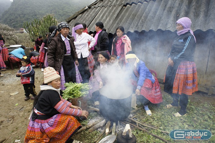 Các gia đình người Mông quây quần nấu cỗ ngay trong vườn nhà (Ảnh: Báo Giáo dục Việt Nam). 