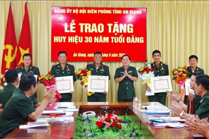 Thượng tá Nguyễn Văn Hiệp - Bí thư Đảng ủy, Chính ủy Bộ đội Biên phòng tỉnh trao huy hiệu 30 năm tuổi Đảng cho các Đảng viên.