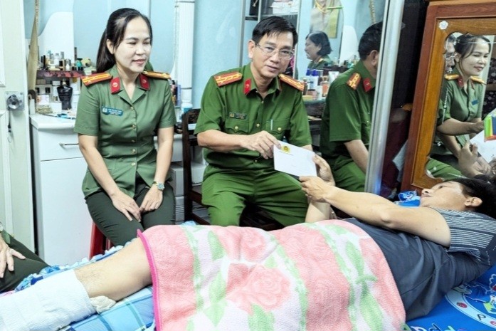 Đại tá Trần Văn Cung, Phó Giám đốc Công an tỉnh trao quà của Đảng ủy, Ban Giám đốc Công an tỉnh cho Đại úy Nguyễn Văn Được.