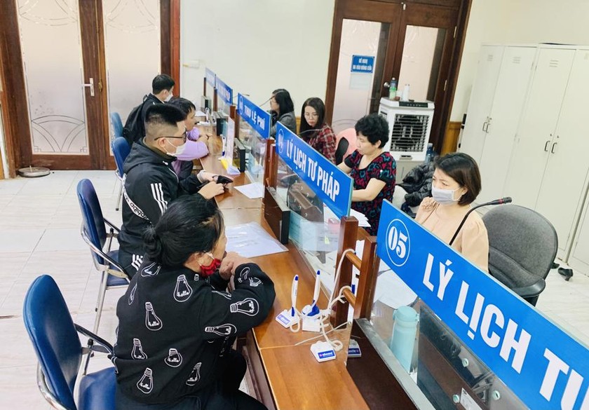Người dân thực hiện thủ tục hành chính tại bộ phận một cửa của Sở Tư pháp Hà Nội chiều 10.4, ảnh: KTĐT
