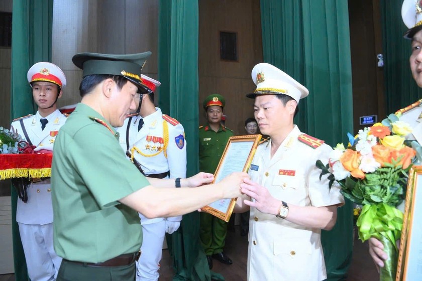 Đại tướng Lương Tam Quang trao quyết định và tặng hoa chúc mừng Đại tá Nguyễn Hữu Mạnh, Giám đốc Công an tỉnh Ninh Bình mới. Ảnh: Công an cung cấp. 