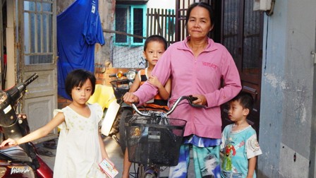 Hàng ngày, bà Hoa dắt theo ba đứa cháu lang thang khắp nơi bán vé số