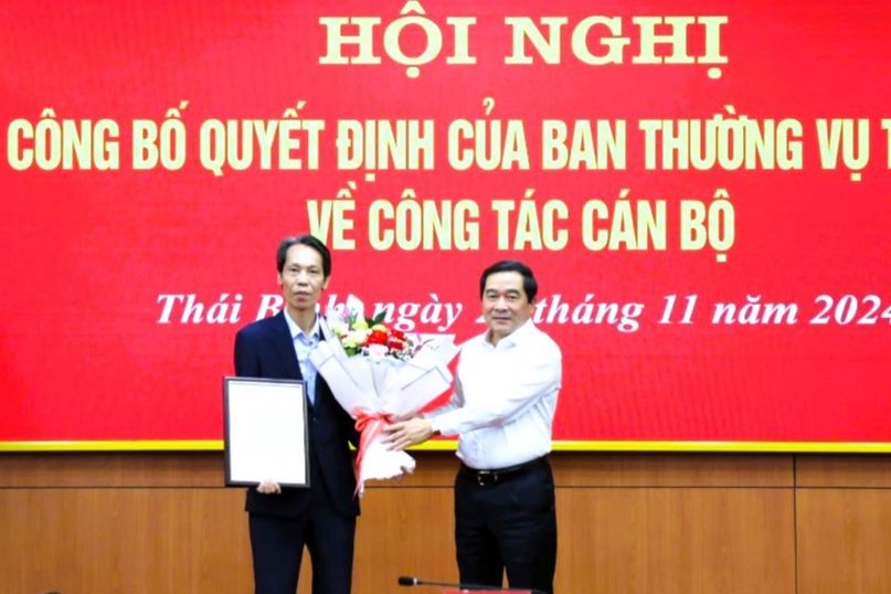 Ông Nguyễn Tiến Thành, Chủ tịch HĐND tỉnh Thái Bình trao quyết định và tặng hoa chúc mừng ông Nguyễn Duy Chiến.