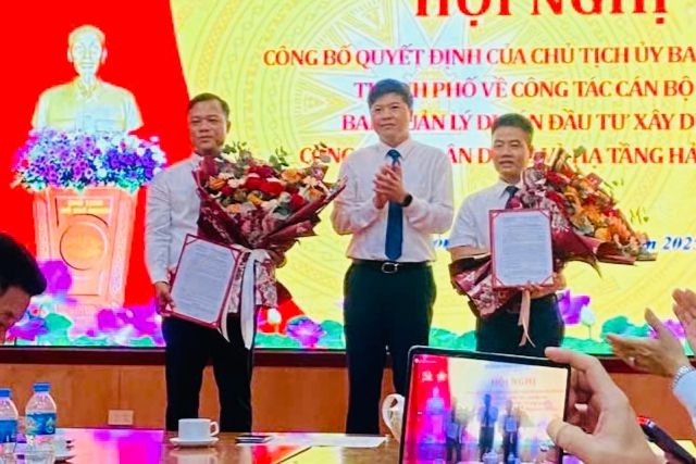 Phó Chủ tịch UBND TP Hoàng Minh Cường trao quyết định, tặng hoa chúc mừng ông Lương Văn Công và ông Trần Ngọc Trung.