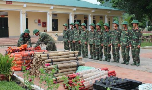 Đại úy Nguyễn Đình Thật - Đại đội trưởng, Đại đội 10, Tiểu đoàn 3, Trung đoàn 1 hướng dẫn chiến sỹ cách sắp đặt dụng cụ phòng chống bão lũ. Ảnh: Tường Hiếu