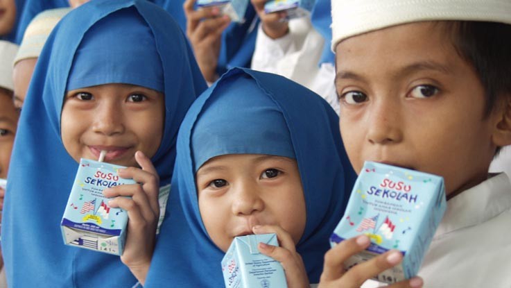 Hình ảnh học sinh tại Indonesia uống sữa cùng bạn bè (nguồn: internet) De an sua hoc duong: Vi tam voc tre em Viet Nam hinh anh 1