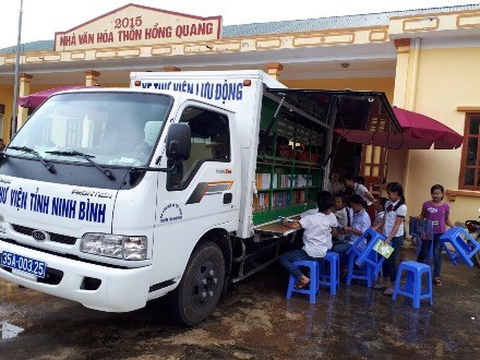 Người dân thôn Hồng Quang, xã Xích Thổ đọc sách từ xe thư viện lưu động. Nguồn. Báo Ninh Bình