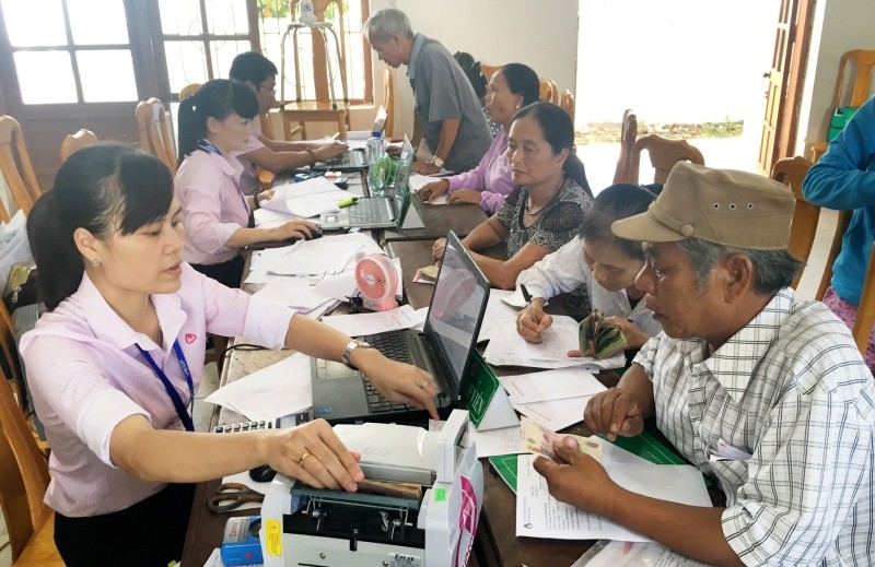 Người dân làm thủ tục vay vốn hỗ trợ giảm nghèo tại một điểm giao dịch của NHCSXH