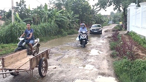 Người dân địa phương vất vả đi qua tuyến đường.