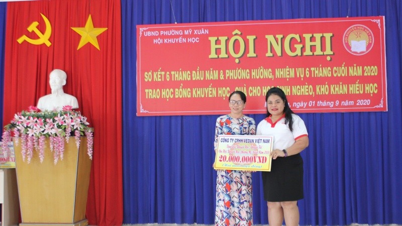 Bà Nguyễn Thu Thủy - Phó Giám đốc đối ngoại Vedan Việt Nam trao bảng tượng trưng số tiền tài trợ cho đại diện Hội Khuyến học phường Mỹ Xuân, thị xã Phú Mỹ.