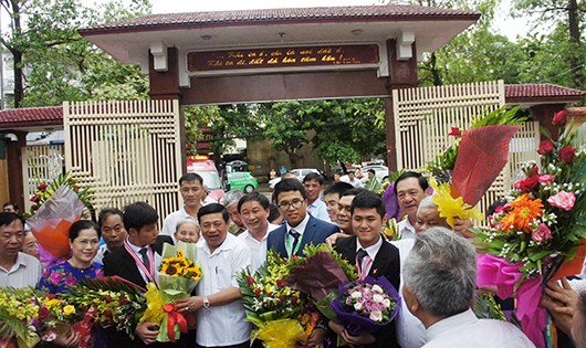 Hai học sinh đạt Huy chương Vàng trong kỳ thi Olympic Quốc tế được lãnh đạo tỉnh đón và tặng hoa chúc mừng.  