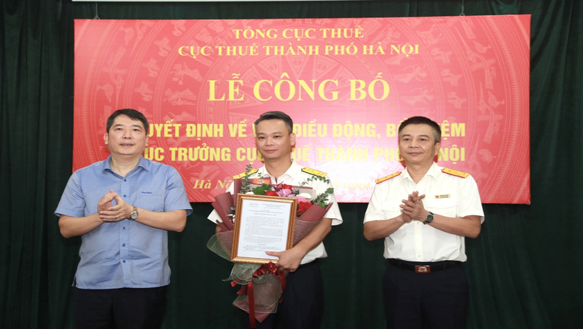 Thứ trưởng Bộ Tài chính Cao Anh Tuấn (bìa trái), Quyền Tổng cục trưởng Tổng cục Thuế Mai Xuân Thành (bìa phải) trao Quyết định và tặng hoa cho tân Cục trưởng Cục Thuế TP Hà Nội Vũ Mạnh Cường.