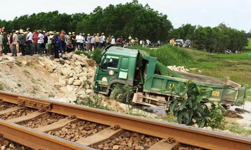 Ôtô tải chở đá bị tàu hỏa hất văng xuống ruộng. Ảnh: Thạch Thảo.