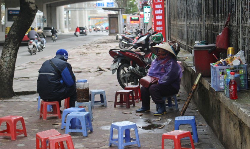 Bán hàng từ sáng sớm, bà Hoa phải khoác thêm một chiếc áo mưa mỏng để bớt đi phần nào cái rét thấu xương.