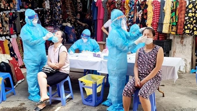 Lấy mẫu cho các tiểu thương chợ Thanh Xuân Bắc. Ảnh: Hanoi.gov.vn