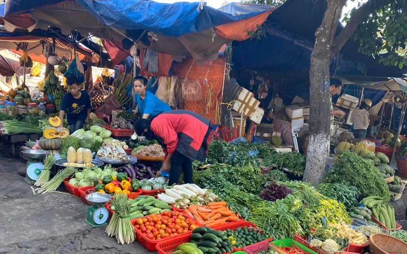 Tiểu thương ở một sạp rau chợ Tân An không đeo khẩu trang khi bán hàng