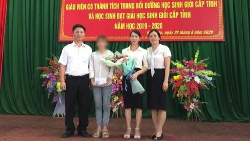 Nữ sinh nhận thư và hoa chúc mừng từ thầy hiệu trưởng.