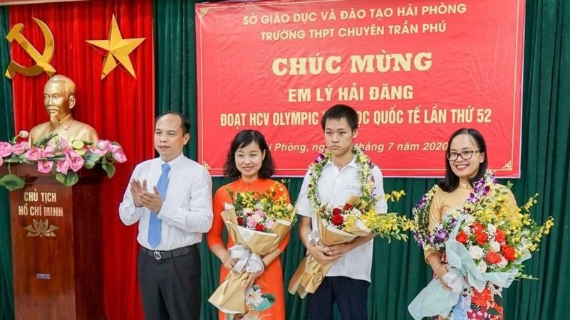 Giám đốc Sở GD&ĐT Lê Quốc Tiến tặng hoa chúc mừng em Lý Hải Đăng và mẹ cùng cô giáo hướng dẫn.